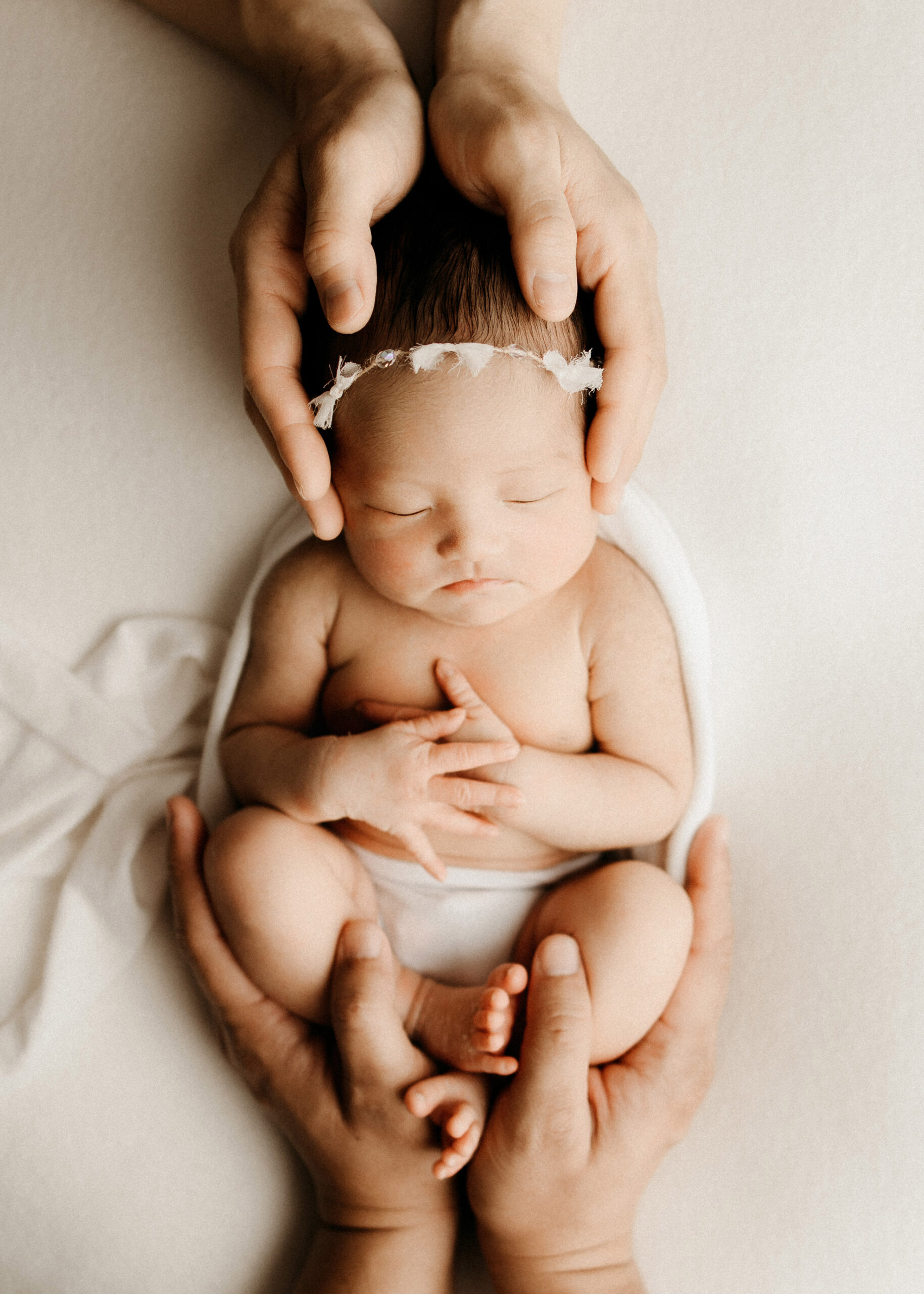 newborn baby girl with parents hands