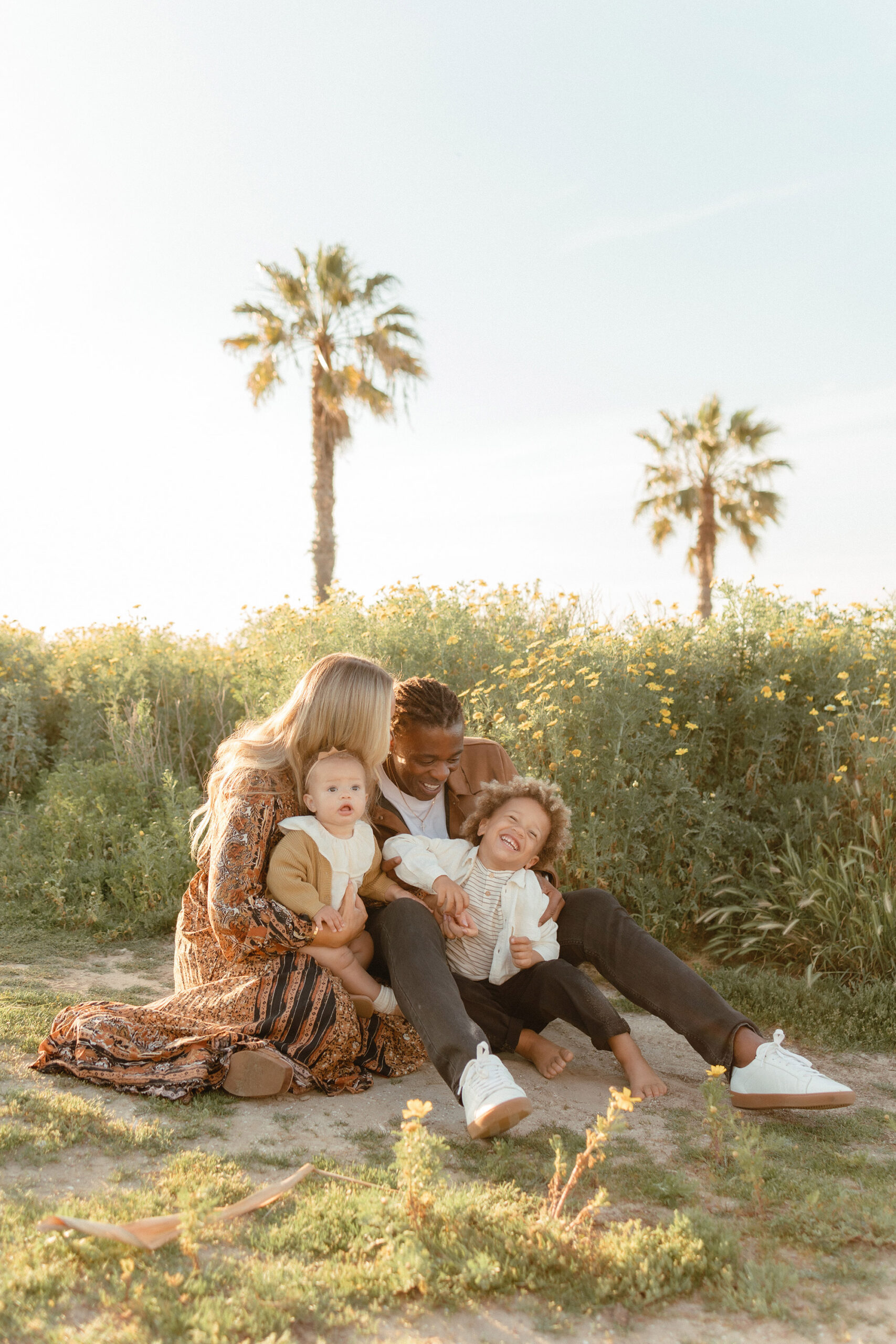 San Diego family photos in wildflowers during golden hour with parents and children sitting together